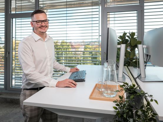 Muž pracuje v kanceláři u počítače.