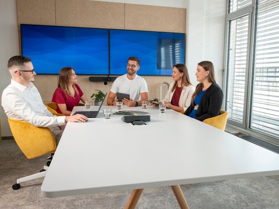 skupina pěti kolegů při meetingu v zasedací místnosti