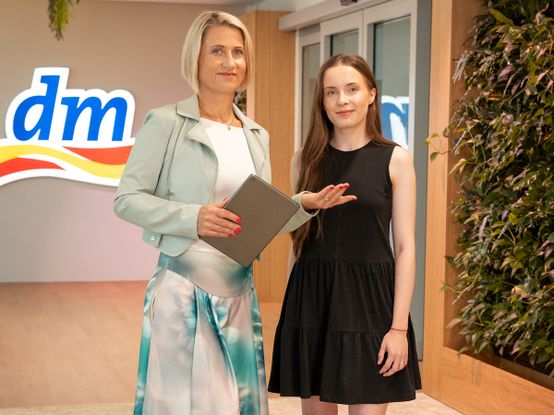 Dvě ženy stojí v prostorách recepce a něco si ukazují.