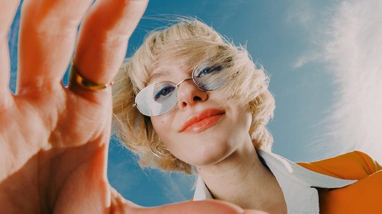 Fotografie k naší kampani Práce mění život zachycuje mladou ženu s brýlemi, která se dívá přímo do objektivu. Tento obraz symbolizuje otevřenost, autenticitu a jedinečnost lidí, které v dm hledáme pro náš týmu. Fotka ke kampani Práce mění život