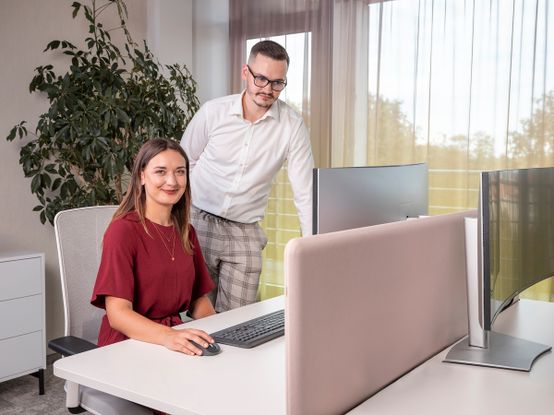 Muž a žena společně v kanceláří pracují na počítači.