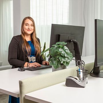 Spolupracovnice sedí u svého notebooku a pracuje.