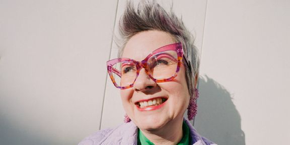 Smějící se žena s výraznými brýlemi. Fotka ke kampani Práce mění život